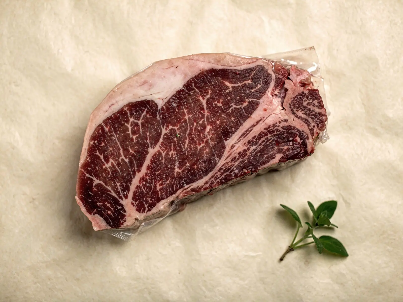 Filete de wagyu crudo envasado al vacío, con el marmoleo blanco repartido por la carne (imagen generada con IA)